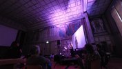 Die Aula ist in violettes Licht getaucht. Auf der Bühne stehen zwei Studentinnen: eine spielt Saxophon, die andere steht am Laptop und mischt Sounds dazu.