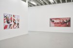 Die Ausstellung zeigt links zwei Arbeiten nah beieinander an der Wand und eine Arbeit rechts an der Rückwand des Raumes. Man kann Körperteile darauf erkennen. In allen Werken besticht die Farbe Rot.