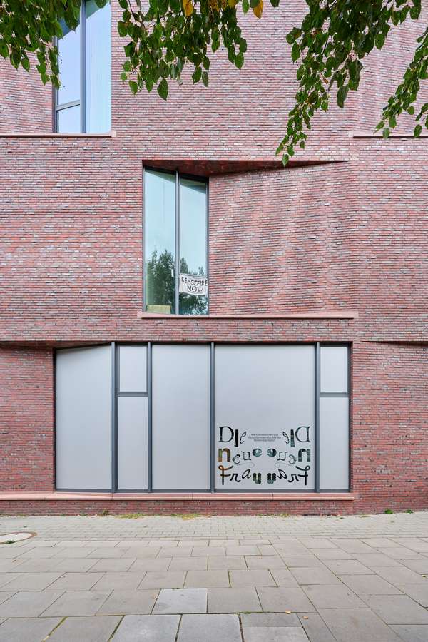 Die Außenaufnahme des AtelierHauses zeigt das große Fenster mit der Folienbeklebung anlässlich der Ausstellung "Die Neue Frau".