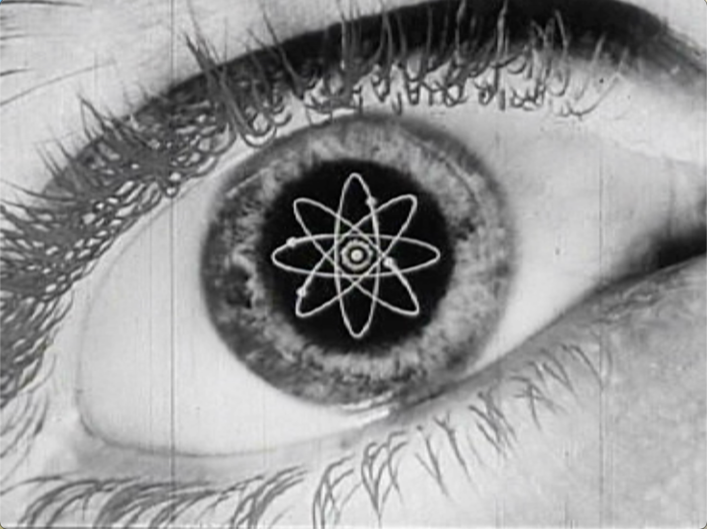 Black-and-white close-up image of a human eye; a stylized atom symbol is visible inside the pupil.