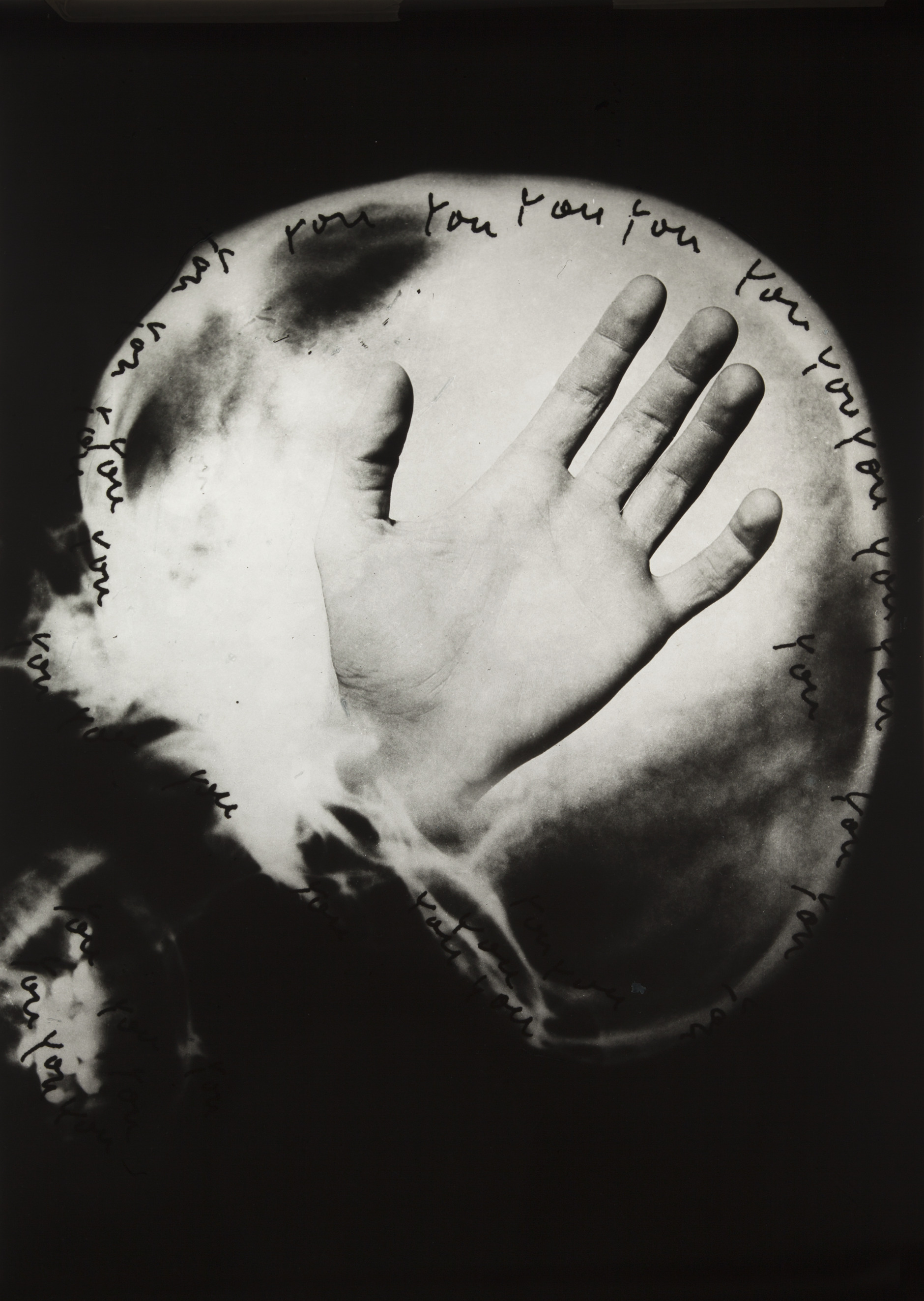 Black-and-white, surreal image showing an upright finger resembling an X-ray, transitioning into a human skull at the bottom; handwritten repetitions of the word “you” surround the finger and skull in circular and scattered patterns against a dark background.