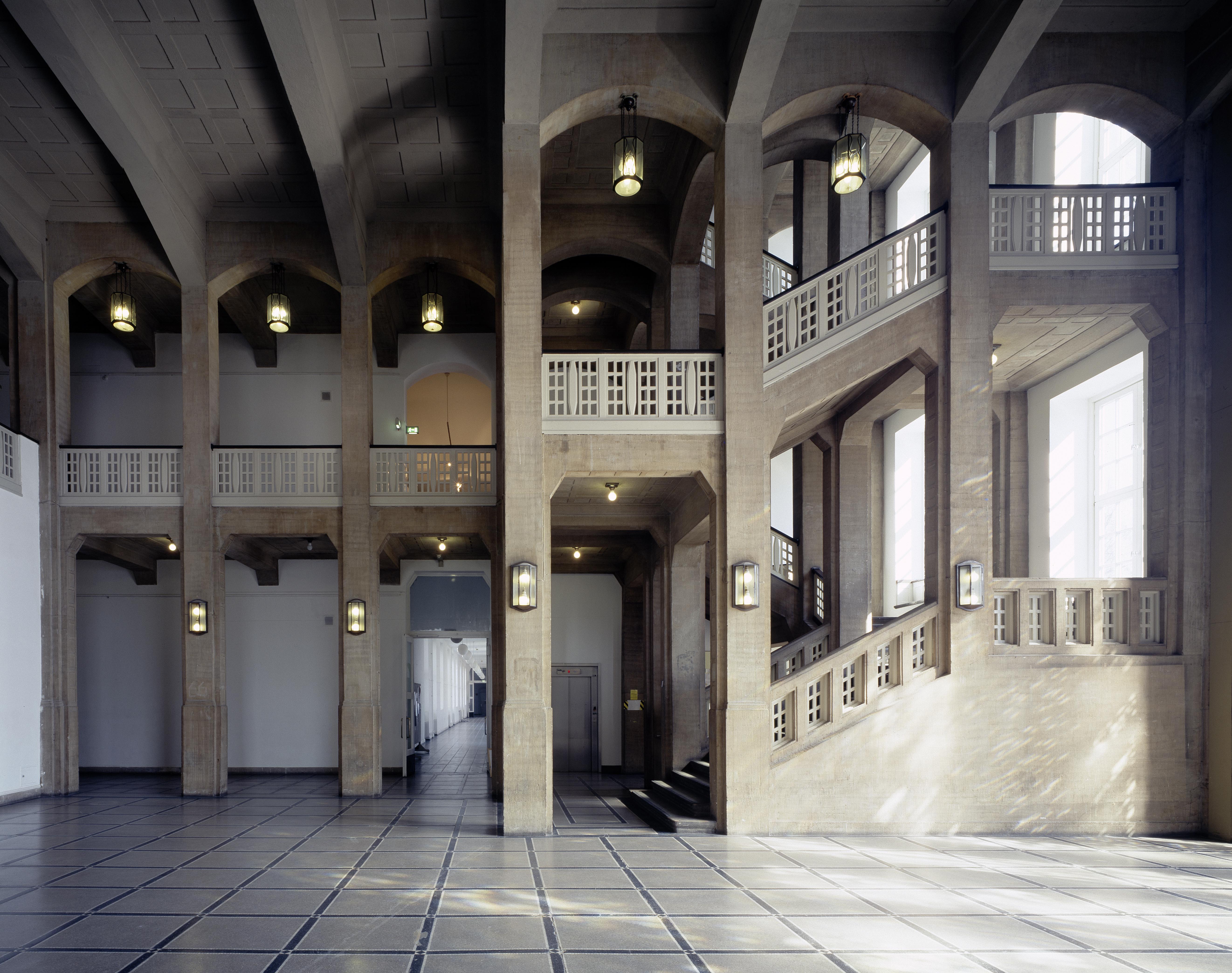 A very tall stairwell with sandstone columns extending up to the ceiling.
