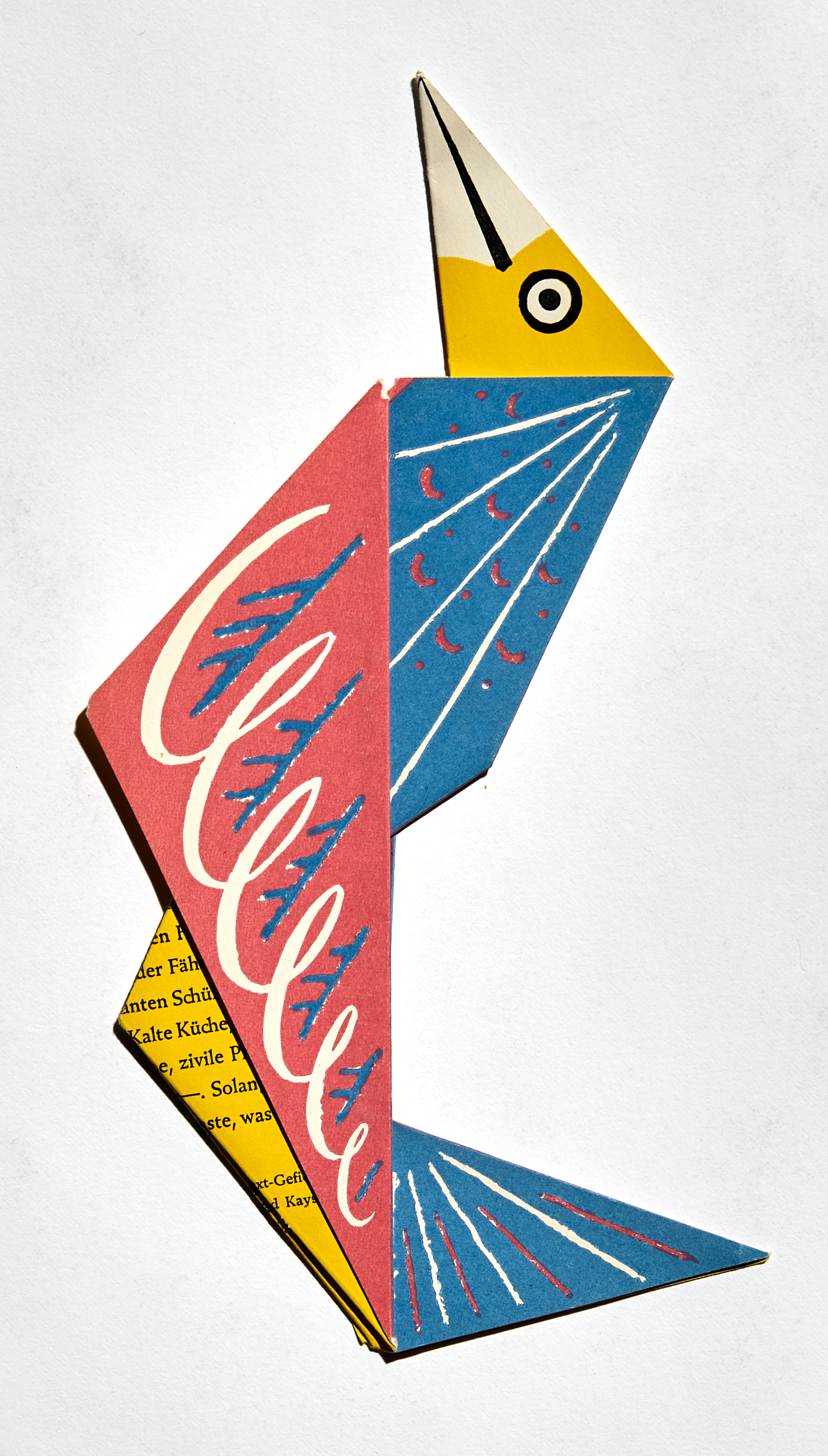 Aus bunten Papier ist ein Vogel als Einladungskarte gefaltet.