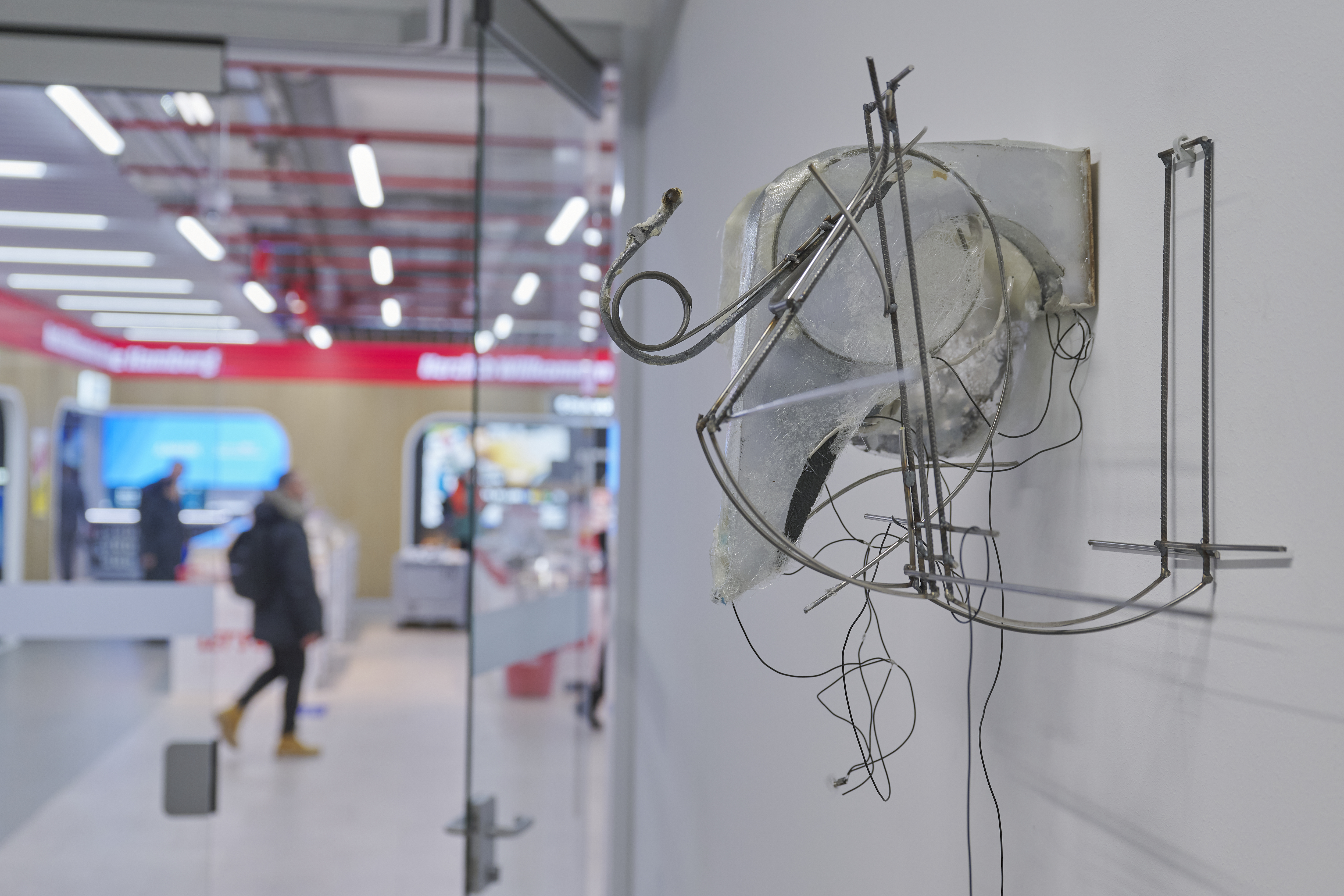 There is an object made of curved metal rods on the wall.