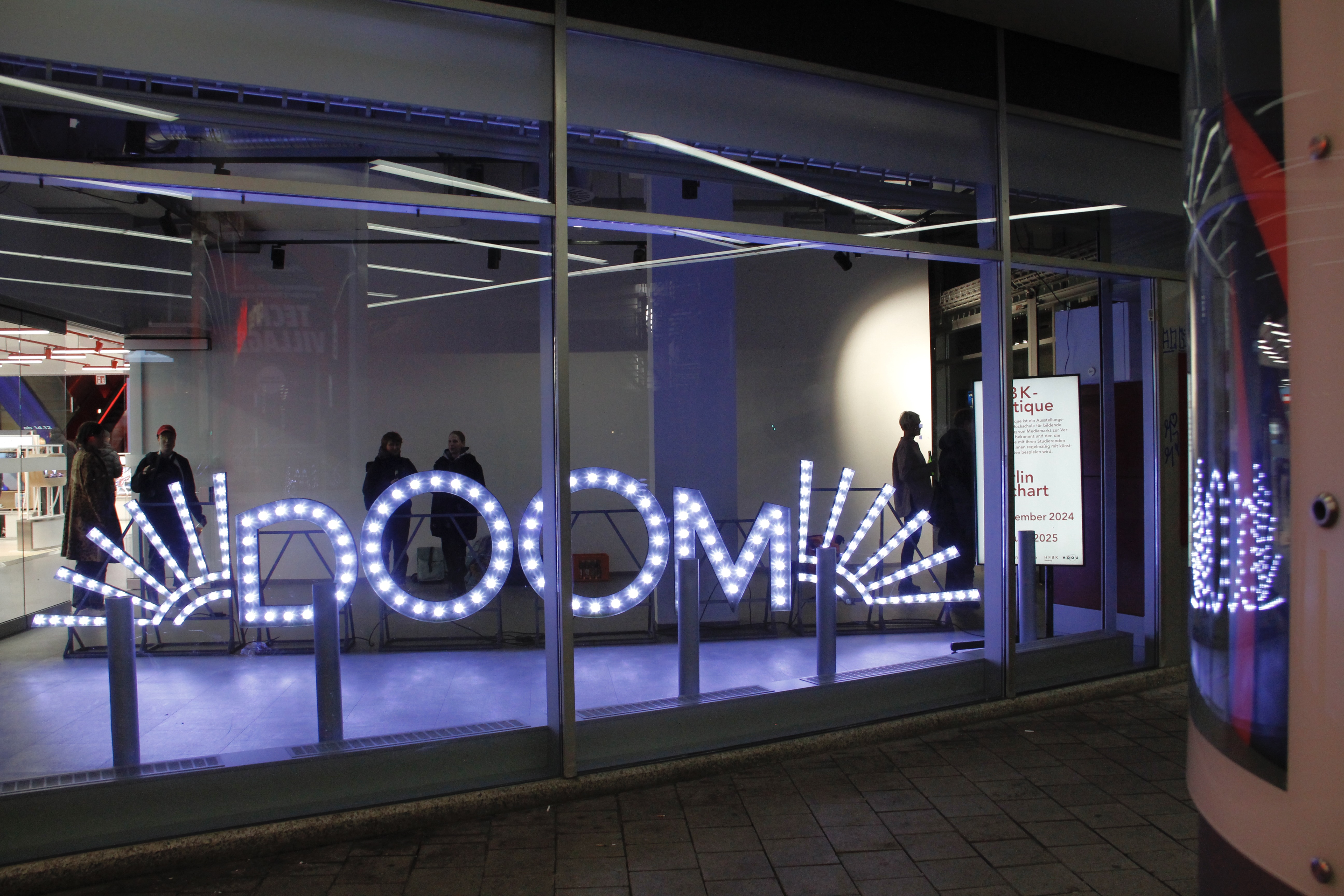 A neon sign with the title DOOM stands in a shop window