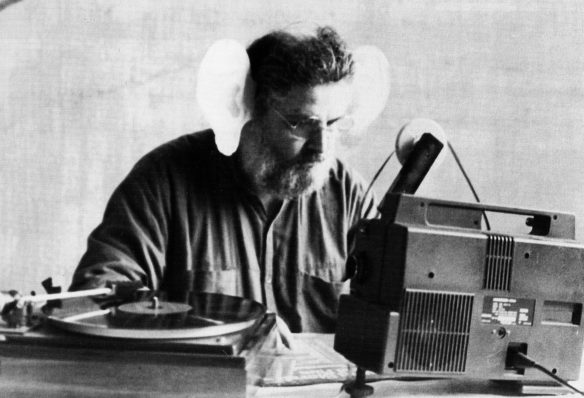 Colorful symbolist painting featuring three human figures: Two people in red garments face each other while a nude figure rises from a large pink flower between them. Two additional figures sit in a floral structure near the bottom. The scene is framed by ornate, symmetrical patterns in vibrant colors.