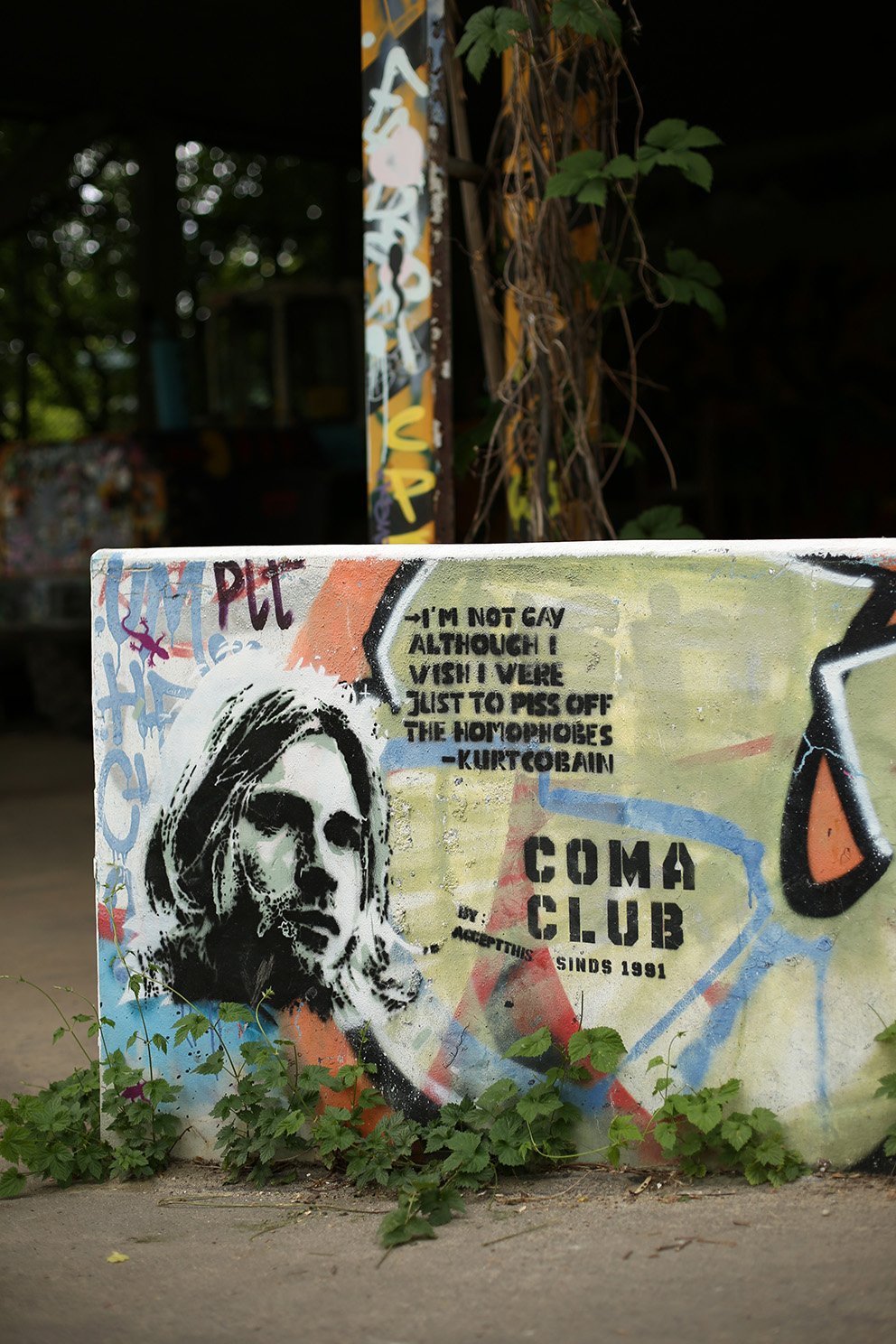 Graffiti portrait of a person on a concrete wall, accompanied by a quoted text and colorful street-art elements.