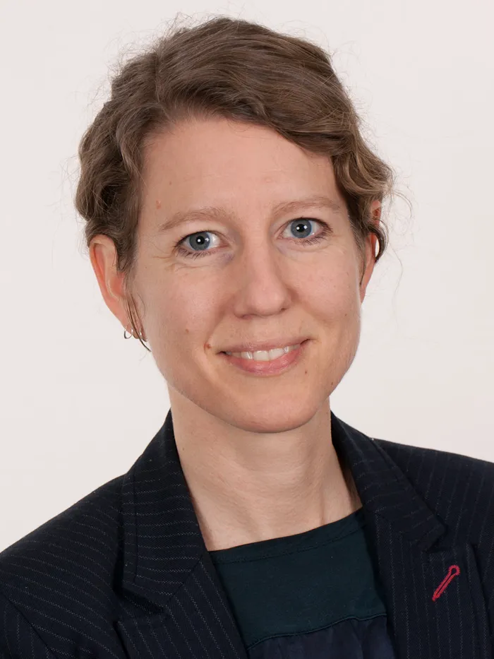 Porträt einer Person vor neutralem Hintergrund.