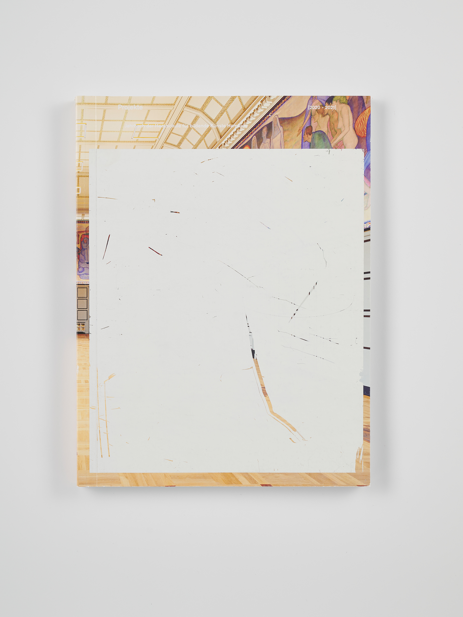 Buchcover mit einer fotografischen Darstellung eines Ausstellungsraums mit Parkettboden und Wandmalereien. In der Mitte überlagert eine große, helle, abstrakte Fläche das Motiv. Am oberen Rand steht in kleiner Schrift „Projekte“ sowie „2020–2021“. Das Buch liegt auf einem neutralen Hintergrund.