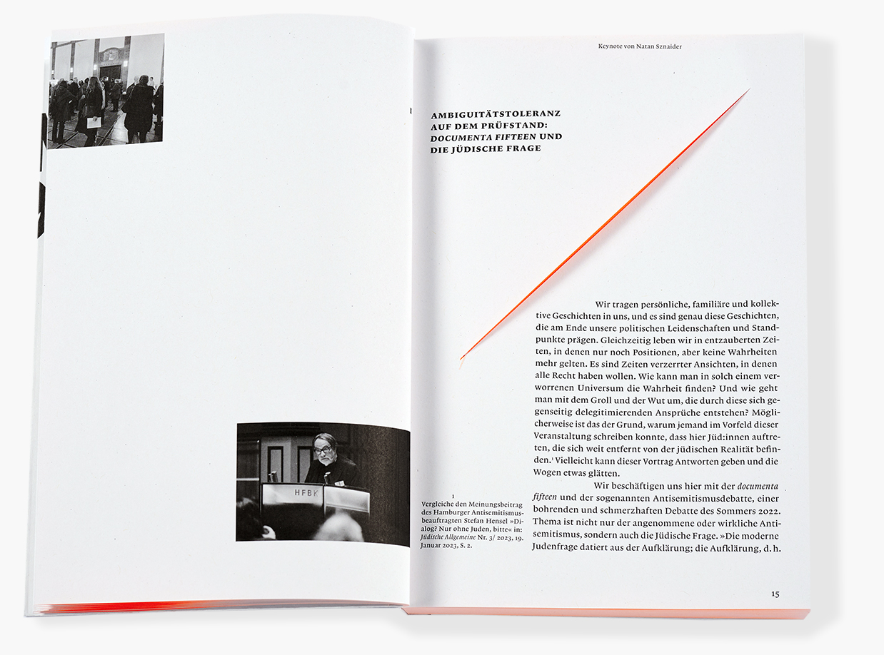 Doppelseite eines Buches mit großzügigem Weißraum. Links oben ein kleines Schwarzweißfoto von Personen in einem Ausstellungsraum, darunter ein weiteres Schwarzweißfoto eines Mannes am Rednerpult mit der Aufschrift „HFBK“. Rechts die Titelseite eines Beitrags mit der Überschrift „Ambiguitätstoleranz auf dem Prüfstand: documenta fifteen und die jüdische Frage“ sowie der Zeile „Keynote von Natan Sznaider“. Eine diagonale rote Linie verläuft über die rechte Seite. Unten beginnt der Fließtext des Essays.