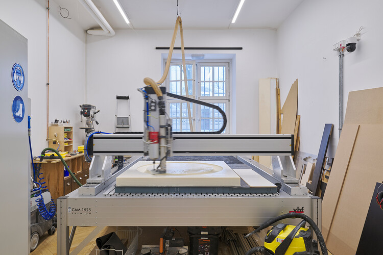 Der Arm einer Fräsmaschine bewegt sich durch eine Kunststoffplatte