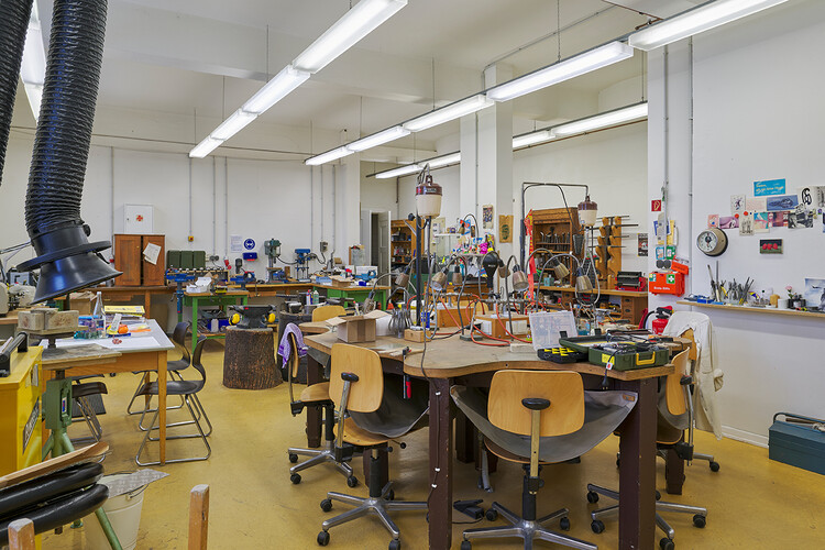 Viele Stühle um einen Tisch, ein Luftohr hängt in den Raum, überall Werkzeug