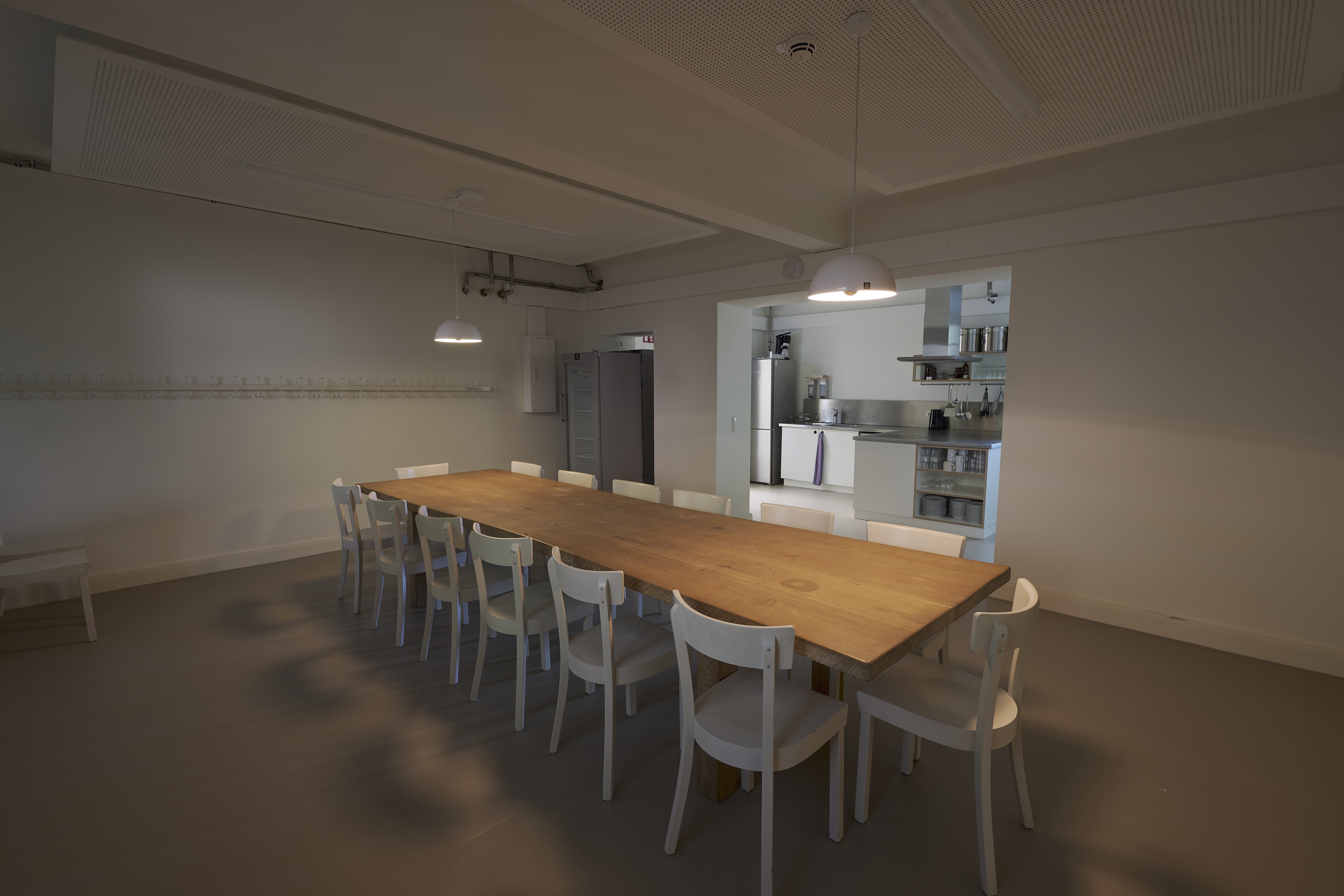 Ein Holztisch mit Stühlen und einem Durchgang in die Küche