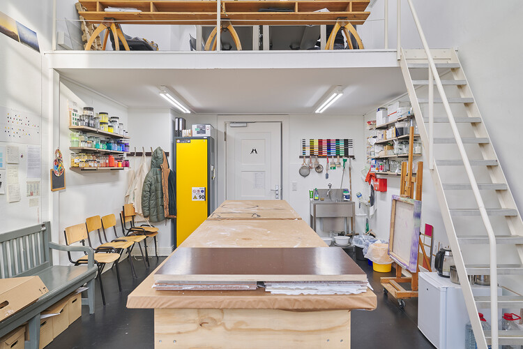 Ein Raum mit einer Treppe, einem großen Tisch und Farbdosen