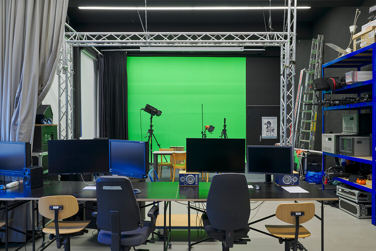 Ein Raum mit Traversen, einer grünen Tapete von der Decke und Zubehör in einem Regal an der Seite