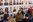 Viele Menschen stehen vor einer Wand mit Portrait-Fotografien